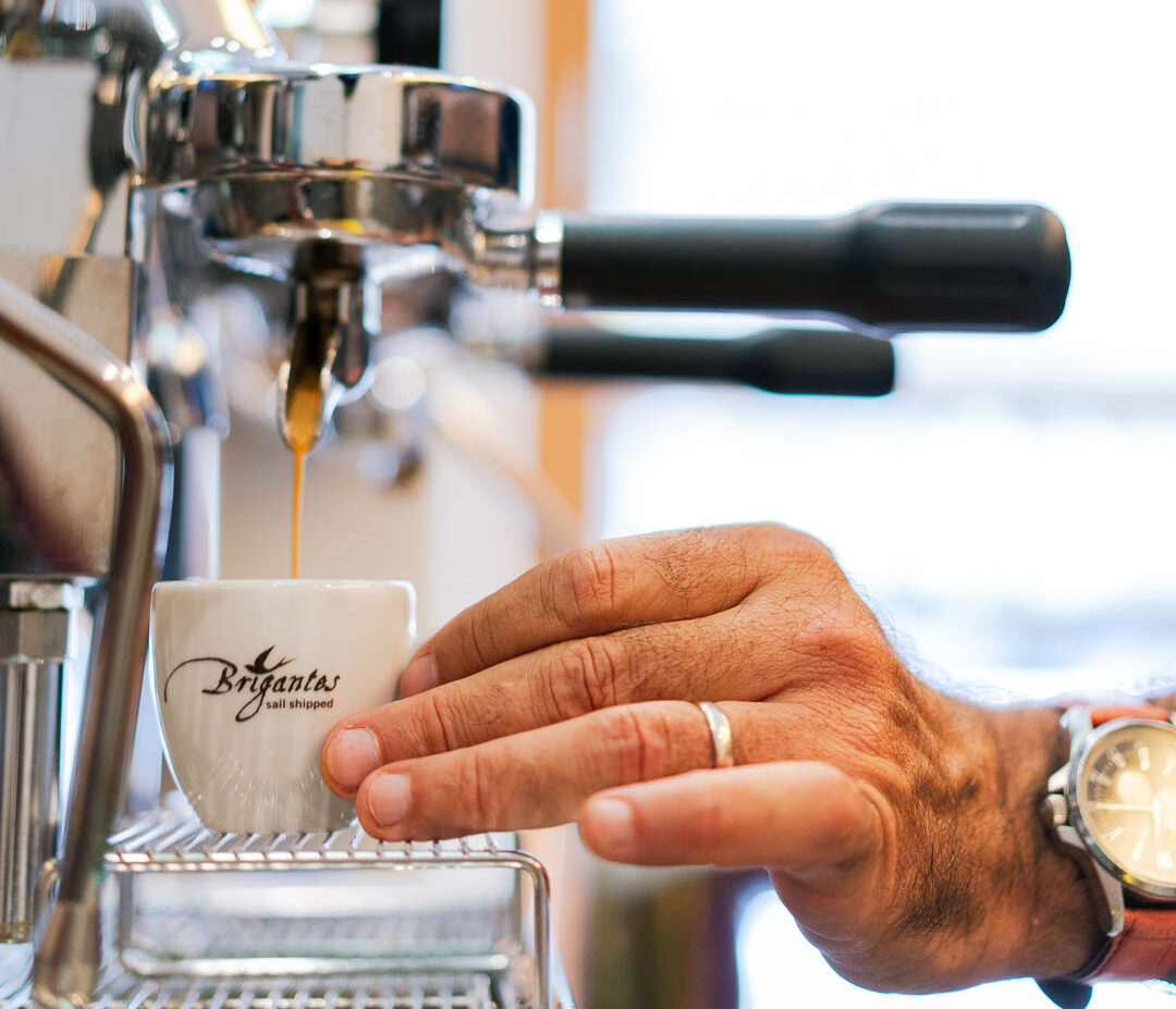 Espresso, der gerade aus der Kaffeemaschine in die Tasse läuft.